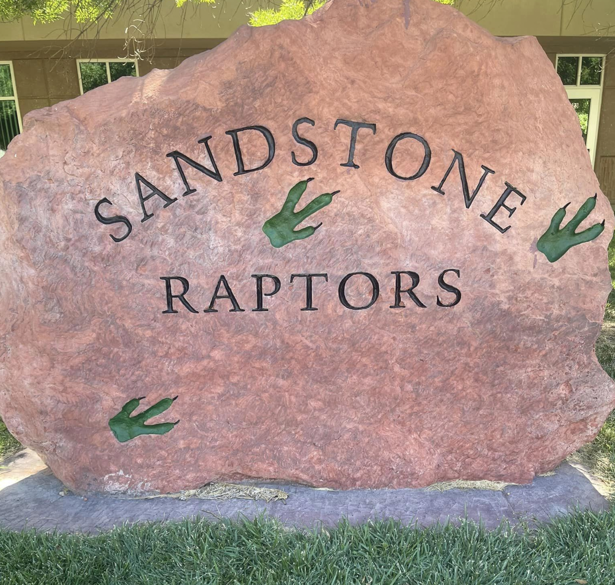 Sandstone Raptors stone plaque outside of building.